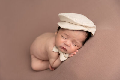 baby sleeping with hat and bow tie by Philadelphia Newborn Photographer