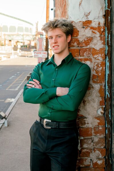 senior boy in downtown phoenix smiling at camera with arms crossed