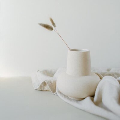 Minimalist vase on a desk with natural light, symbolizing calm and focus during content mapping and course structure planning.