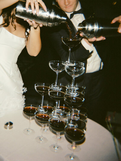 film wedding photography at Shinola Hotel shows a couple pouring an espresso martini tower 