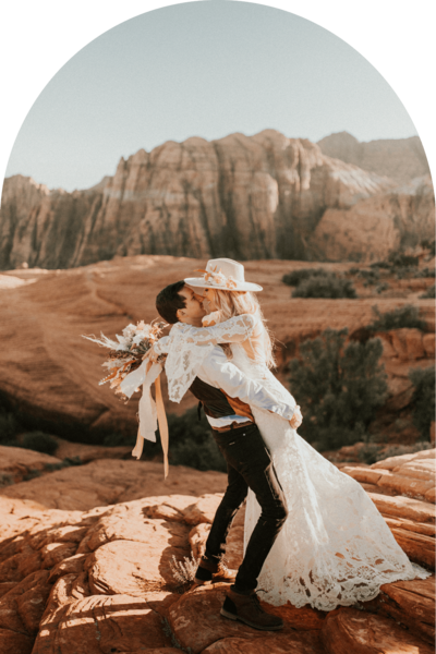 man holding bride up and kissing