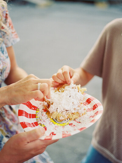 Family's fingers dive into a sugary funnel cake at the state fair documented on film