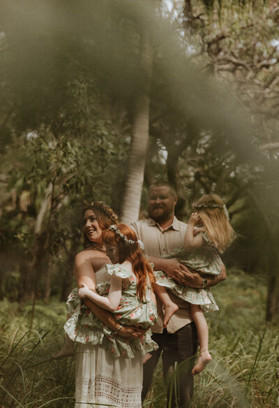 Family of 4 standing the bush together, looking out into the distance