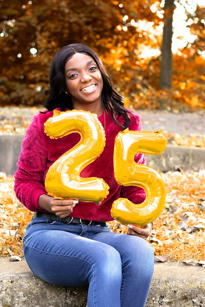 Fall PWoman in red velour sweater holding the number 23 in balloonsortrait Photoshoot at Frog Island in Ypsilanti, MI
