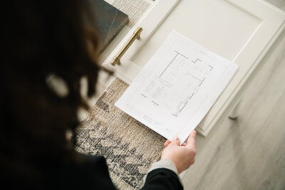 A woman looks at a floor plan printout in her office