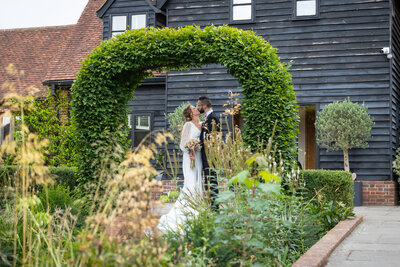 A bride and groom kiss outside during their summer wedding.