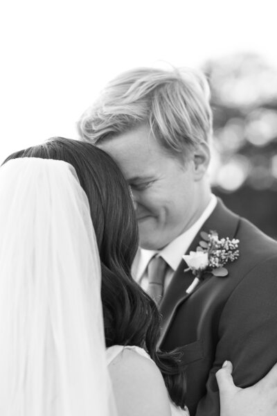 An elegantly captured black and white photo of a bride and groom hugging, beautifully preserved by an Austin wedding photographer.