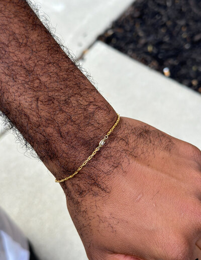 A male client showing his custom permanent bracelet from Jazzy's Glam Bar.