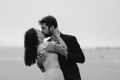 black and white image bride and groom kissing