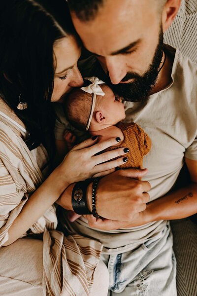 a candid moment with new parents and their baby in their home after birth.