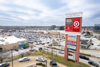A drone photo of a sign for a shopping center, with the stores listed in the background.