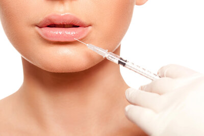 Jaci Rich in Midland, TX offers filler to help you combat volume loss and aging. This is an image of a woman looking into a mirror. She provides lip, cheek, eye, and other facial filler services,