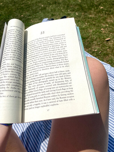 Person sitting on the grass holding an open book