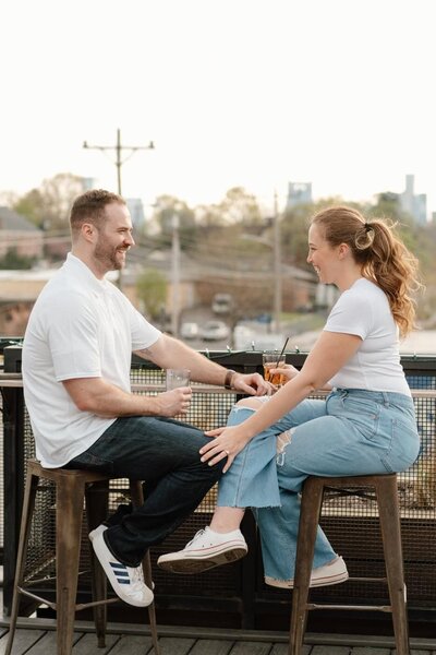 couple sharing a drink at a bar in east nashville during engagement session