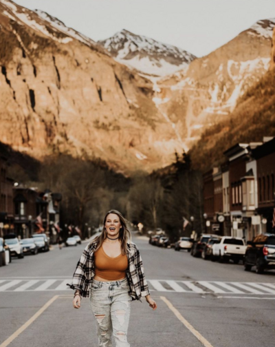woman standing in street in front of mountains