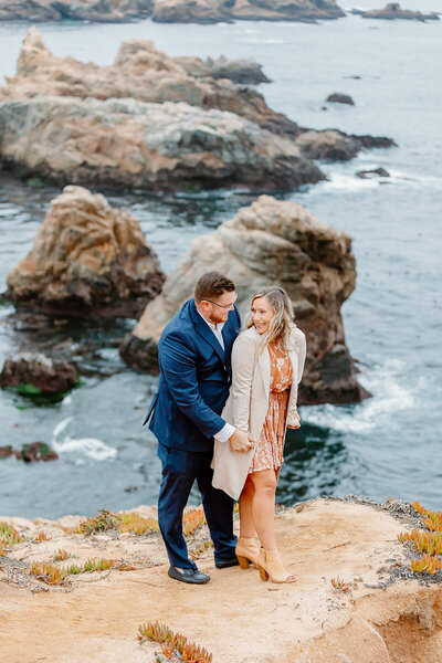 big sur engagement couple posing on cliff