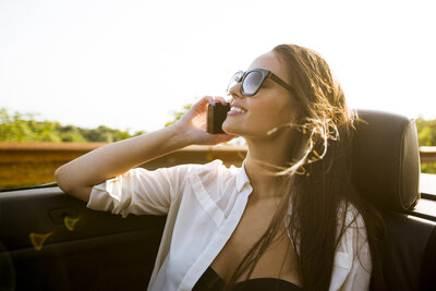 woman-uses-mobile-phone-and-siting-in-cabriolet-at-2023-11-27-05-08-39-utc