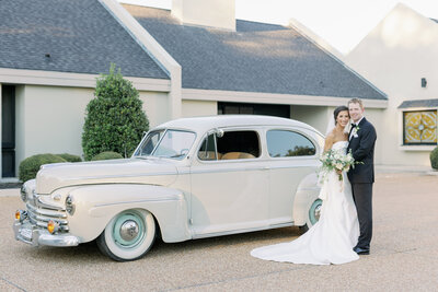 Couple smiling in front of a car