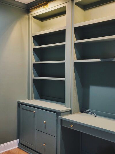 green built in bookhelves and cabinet with drawers and desk space