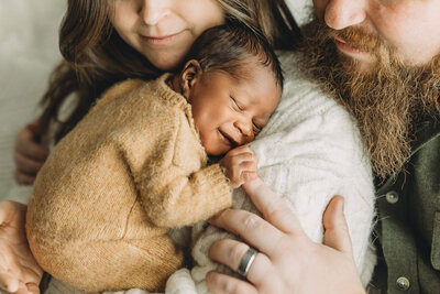 newborn boy sleeping on his tummy on a green backdrop with a tiny newborn sleepy cap in harrisburg pa newborn session