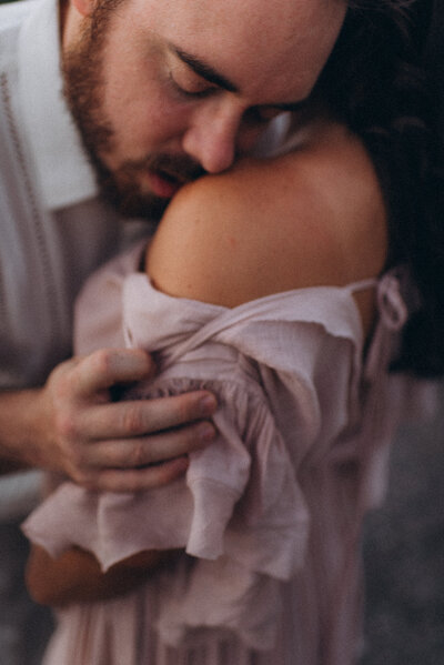 A husband and wife hugging in a Scottsdale park