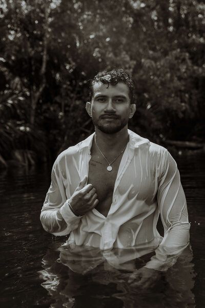 Black and white photo of man standing in water