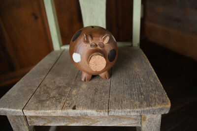 Piggy bank sitting on a wooden chair