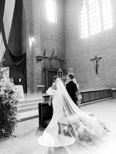 Bride and groom kneeling at the altarin the church during their wedding ceremony in Colombia.