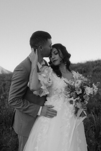 Groom kissing bride at joshua tree wedding