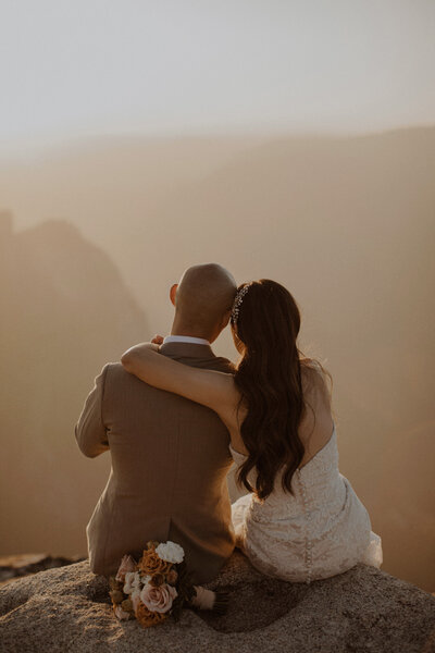 Eloping couple snuggles together at Taft Point