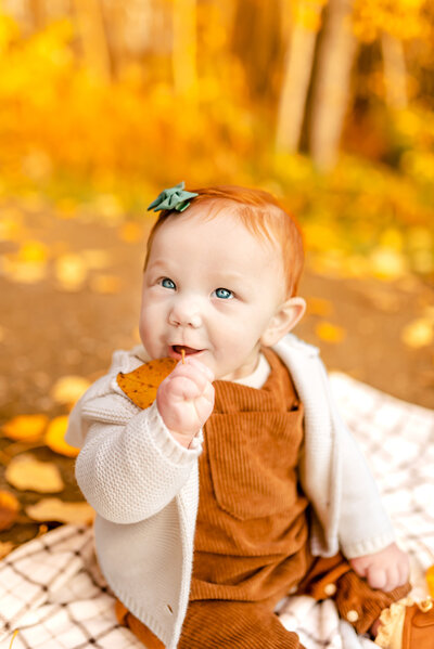 Baby during fall family session with fall leaves