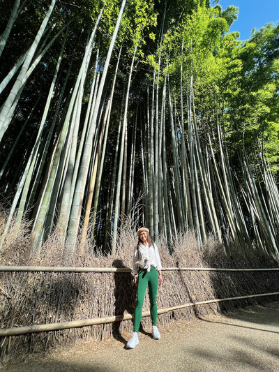 Aireen standing in front of towering bamboo trees in Kyoto