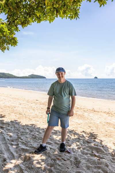 Young man standing on the beach at Palm Cove. 