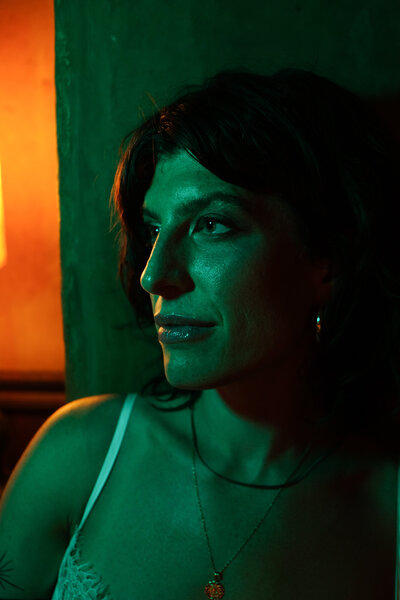 Portrait of founder Tristan Thibodeau gazing ahead with confidence, lit by moody green and orange tones—symbolizing purpose, presence, and power in brand leadership.