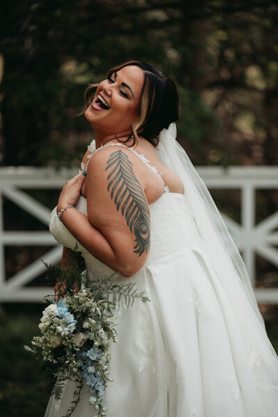 candid moment of bride laughing with bouquet in hand