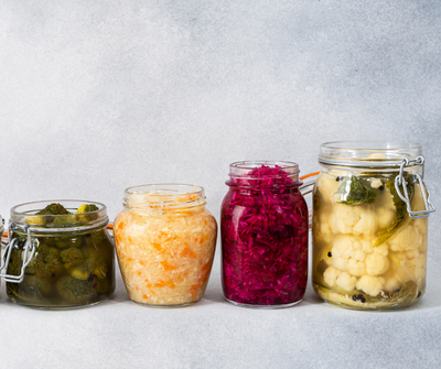 Hands slicing a head of purple cabbage on a cutting board, demonstrating fresh, nutrient-dense food preparation.