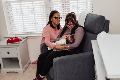 Doula compassionately helping a mother with her baby during breast feeding