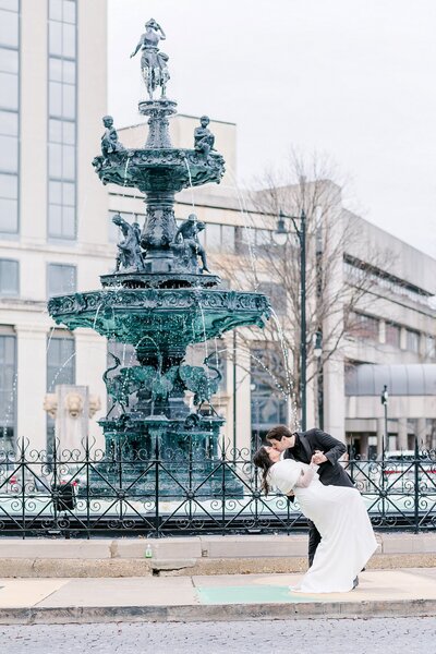 Bride and groom kiss beside Court Square Fountain in Montgomery | Wedding photography by Amanda Horne
