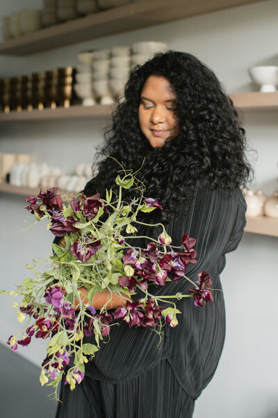June Bloom Owner, Joanne, holding a floral arrangement.