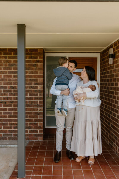 Photo of a family standing outside their house