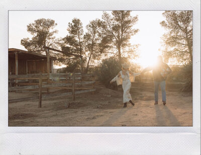 A male and female walking with baby on ranch at sunset