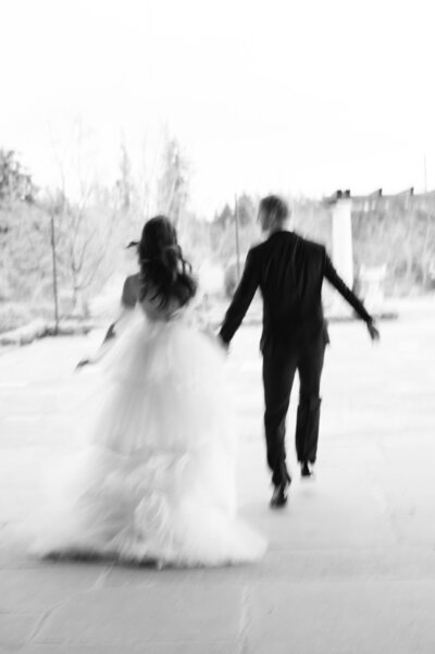 bride and groom running with motion blur in black and white at the chateau de lis