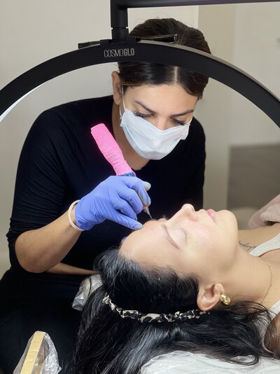 Yanet at Blushed Miami demonstrating a permanent makeup procedure on a client during a training session.