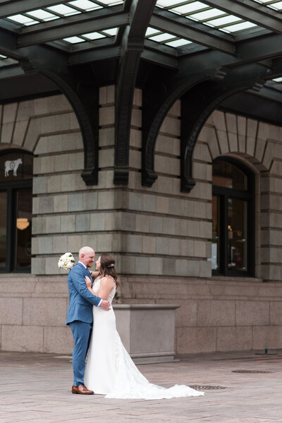 downtown denver wedding with bride and groom embracing each other on a street corner outside of their wedding venue