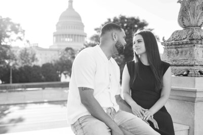 couple sitting in front of the US Capitol for their engagement session