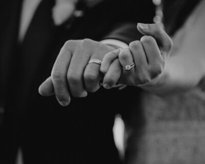 husband and wife interlocking fingers to showcase their wedding bands