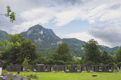 Row of charming Tiny Homes with breathtaking mountain views at TheCampusAlps.com, the perfect Alpine getaway for nature and adventure lovers.