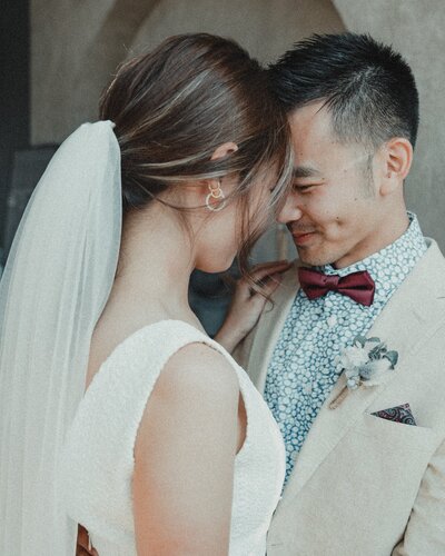 Bride and groom touching forwheads