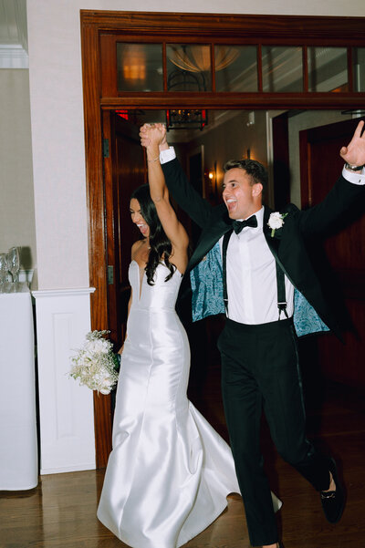 bride and groom on their wedding day making their reception entrance in style at peconic bay yacht club in long island, new york - by Daniella Diaz Wedding Photographer