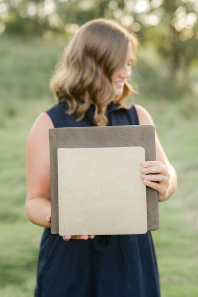 girl holds wedding albums